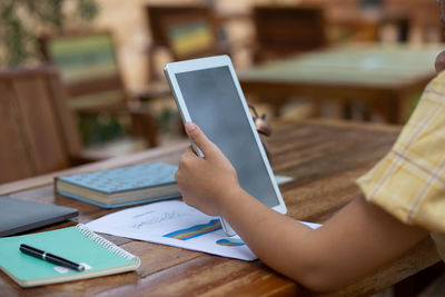 Midsection of man using mobile phone on table