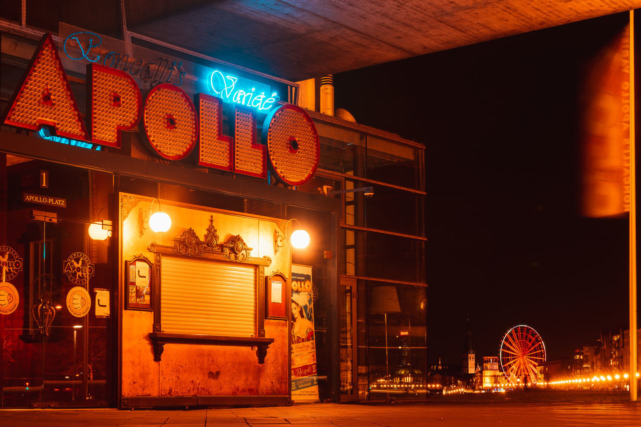 ILLUMINATED STREET LIGHTS ON CITY AT NIGHT