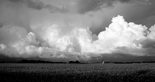 Scenic view of field against cloudy sky