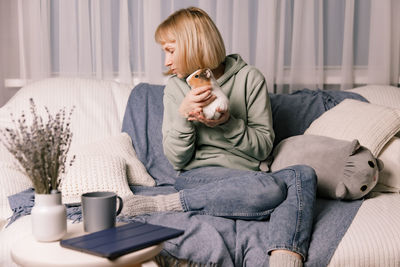 Couple using phone while sitting on bed at home