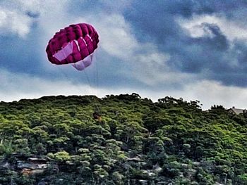 Low angle view of hot air balloons against cloudy sky