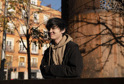 Asian teenage boy with earphones on street. madrid. spain