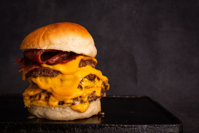 Close-up of burger on table against black background