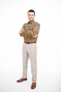 Portrait of young man standing against white background