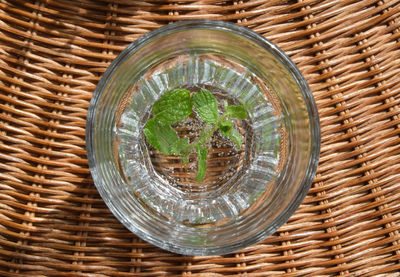 High angle view of drinking glass on wicker seat