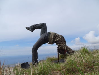 Side view of man on field against sky