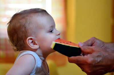 Side view of cute baby eating watermelon
