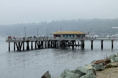 Pier on river against sky