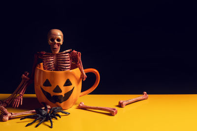 Young woman sitting on table against black background