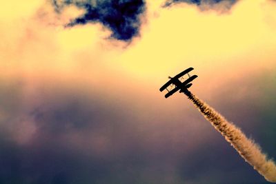 Low angle view of silhouette airplane against sky during sunset