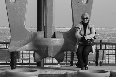 Portrait of young woman standing against built structure