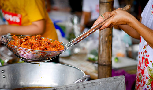 Midsection of man preparing food on barbecue grill