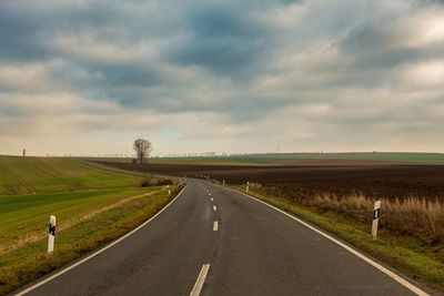 Road passing through landscape against sky