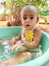 Portrait of cute baby girl sitting in bathtub