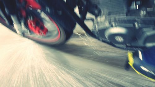 High angle view of motorcycle wheel splashing water on street