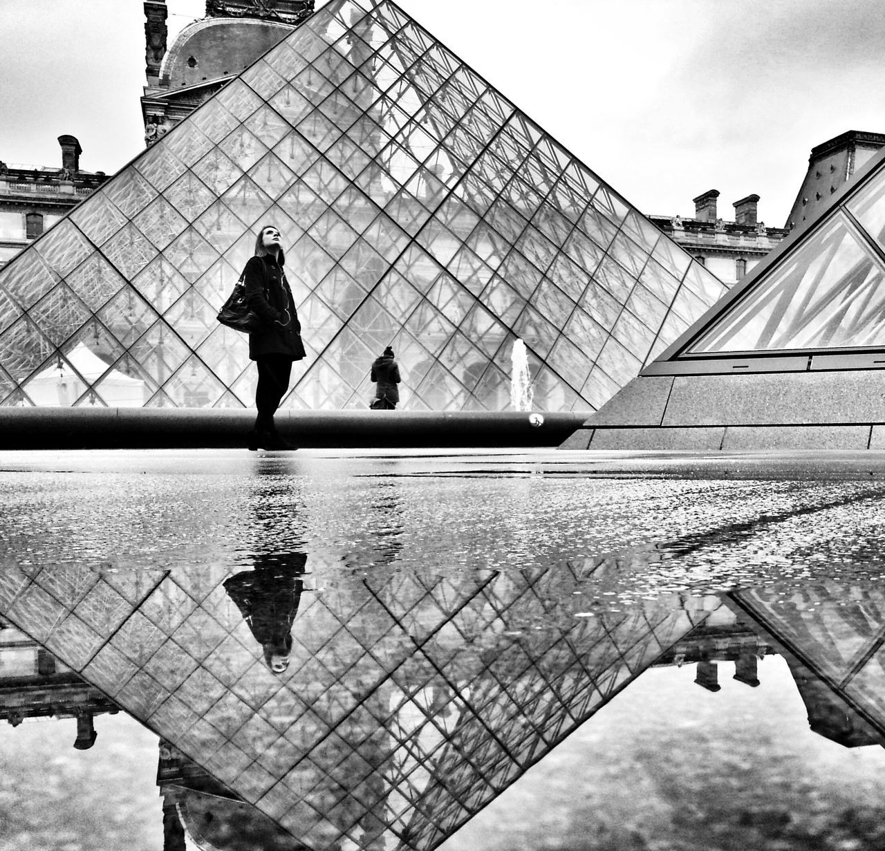 built structure, architecture, building exterior, low angle view, sky, reflection, men, famous place, water, lifestyles, silhouette, travel destinations, tourism, day, full length, cloud - sky, leisure activity, international landmark