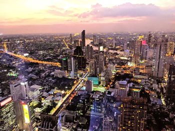 High angle view of illuminated cityscape against sky during sunset