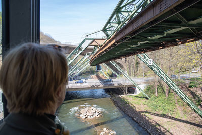 Woman looking out the window of wuppertaler schwebebahn, wuppertal suspension