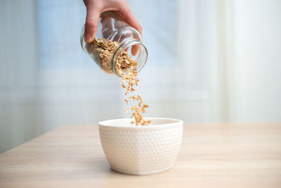 Close-up of person hand holding tea cup on table
