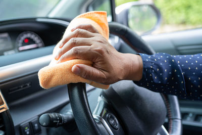 Cropped hand of man driving car