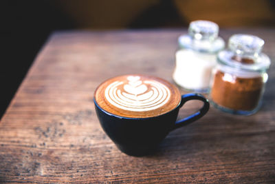 Cup of hot cappuccino on the wooden table. heart is an art latte