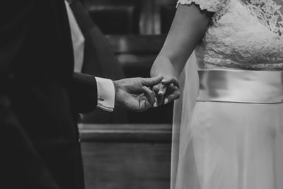 Midsection of couple holding hands