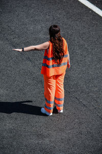 Rear view of girl standing on road