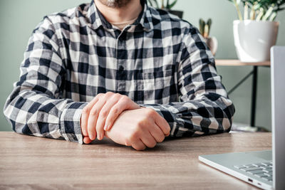 A man suffering from joint pain in his hand and wrist, rheumatoid arthritis and occupational disease