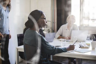 Businesswoman with colleagues at conference table in board room