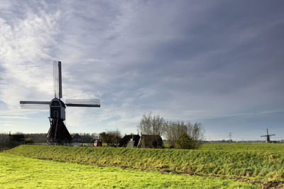 Windmill on field against sky