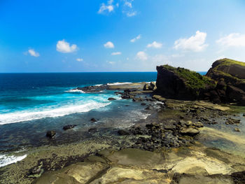 Scenic view of sea against blue sky during sunny day