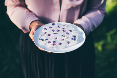 Midsection of woman holding dentures