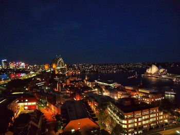 Illuminated cityscape against clear sky at night