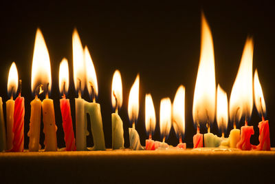 Close-up of burning candles on table in darkroom