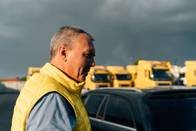 Side view of man against cloudy sky