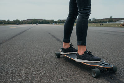 Low section of man skateboarding on road