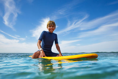 Rear view of man swimming in sea against sky