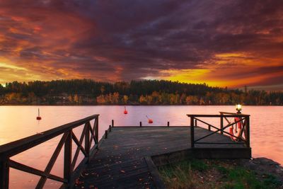 Pier over lake against sky during sunset