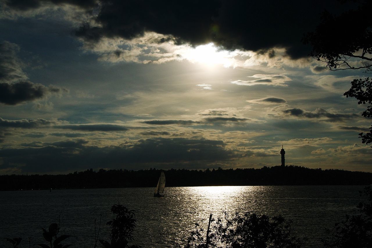 water, sun, silhouette, tranquility, sky, tranquil scene, scenics, beauty in nature, sunlight, sunbeam, reflection, nature, waterfront, sunset, river, cloud - sky, lake, lens flare, idyllic, rippled