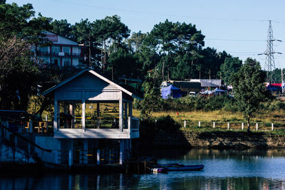 Houses by lake against buildings