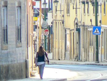 Rear view of women walking in front of building