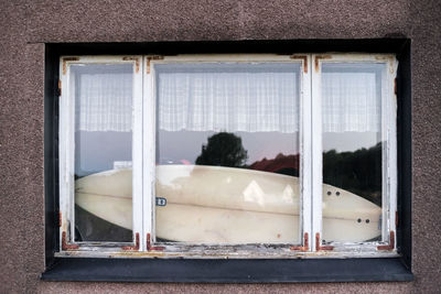 Surfboard in house seen through window
