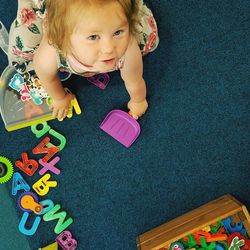 High angle portrait of cute baby playing with toy on floor