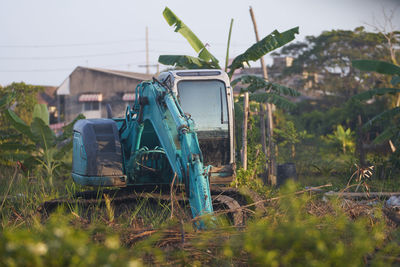 Abandoned digger tractor on field