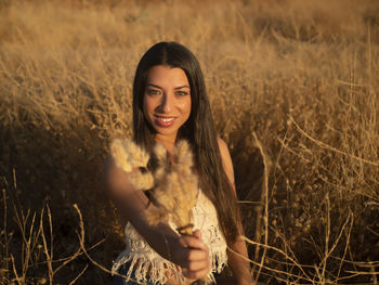 Portrait of young woman standing on field