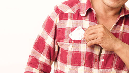 Midsection of man wearing hat against white background