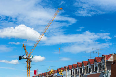 Low angle view of cranes against sky