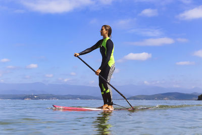 Female sup surfer on a wave