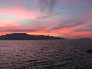 Scenic view of sea against dramatic sky during sunset