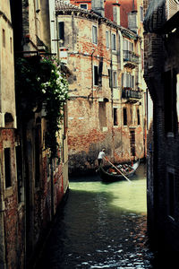 Rear view of man on boat sailing in canal